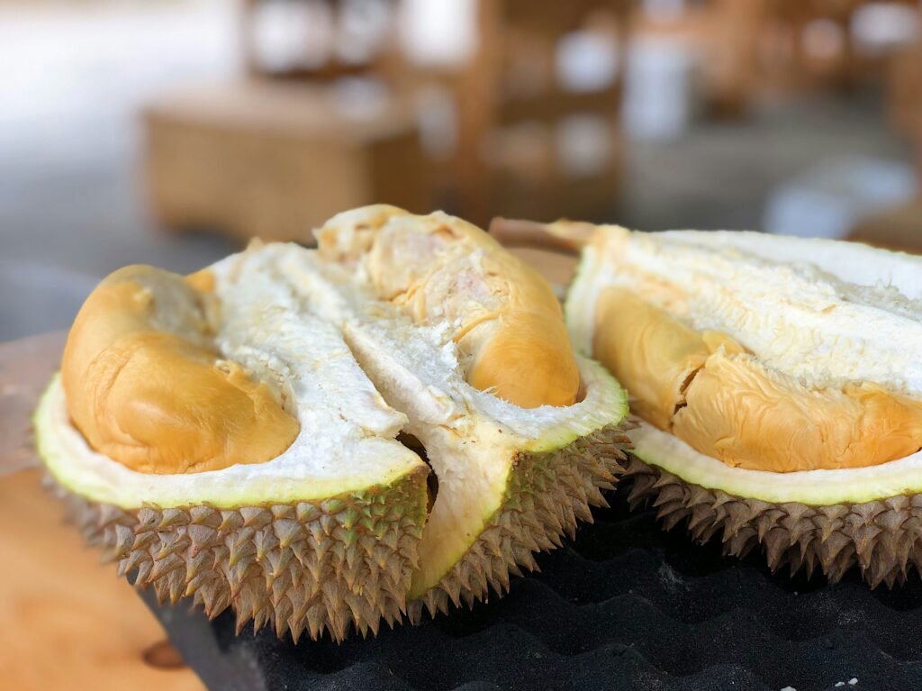 Freshly opened durian with golden yellow flesh at a Kuala Lumpur night market