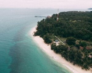 Crystal-clear water and white sand beach on Pulau Kapas, Malaysia, with few tourists around