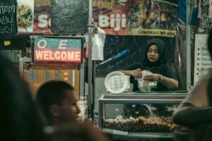 Teh Tarik vendor pulling hot milk tea between two metal cups at a Kuala Lumpur street stall